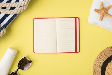 Plaj çantasının en üst görüntüsü beyaz havlu krem şişesi güneş gözlüğü kapağı deniz yıldızı ve açık kırmızı planlayıcı izole edilmiş sarı arka planda boş alan