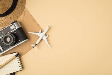 Telif defteri kamerasındaki başlık kaleminin en üst görüntüsü ve el işi kağıt zarf üzerindeki uçak modeli kopyalanmış bej arkaplanlı