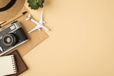 Sunhat Flowerpot 'un en üstteki fotoğrafı. Kalem, pasaport, uçak modeli ve kamera, izole edilmiş bej arka planda, el işi kağıt zarf ve fotokopi makinesi.