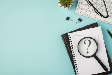 Not defterlerinin sorgulama işareti büyüteç klasörlü üst görünüm fotoğrafı izole edilmiş pastel mavi arkaplanlı kalem, bitki gözlüğü ve klavye.