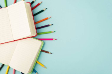 Çoklu renkli kalemlerin üst görünümü kırmızı ve yeşil organizatörlerin izole edilmiş pastel mavi arkaplandaki kopyaları