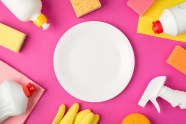 Ortadaki temizleme pedlerinde beyaz tabaka resmi plastik eldivenler ve izole edilmiş pembe arka planda beyaz deterjan şişeleri.