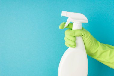 Elin yeşil lastik eldivenli profil fotoğrafı. Atomizer beyaz deterjan şişesi kullanıyor. Üzerinde etiket yok.