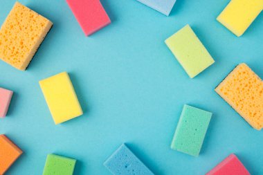 İzole edilmiş mavi arkaplan üzerindeki çoklu renk temizleme yastıklarının ortasındaki telif boşluğunun en üstteki görüntüsü