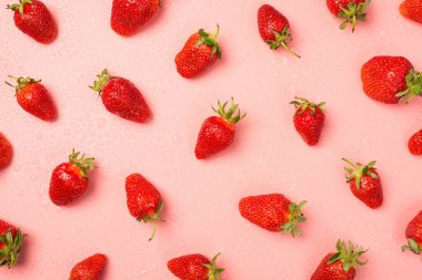 Çilek ve su damlalarının izole edilmiş pastel arka planda en üstteki fotoğrafı.