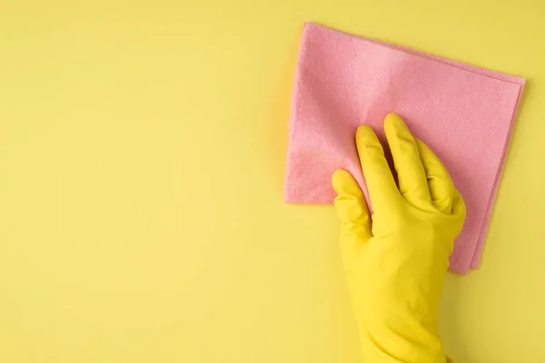 黄色橡胶手套手部用粘胶餐巾纸在隔离黄色背景与彩色空间的透视图照片 — 图库照片
