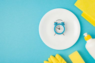 Üzerinde sabun temizleme resmi sarı eldivenler ve çalar saat ile plaka mavi arka planda izole