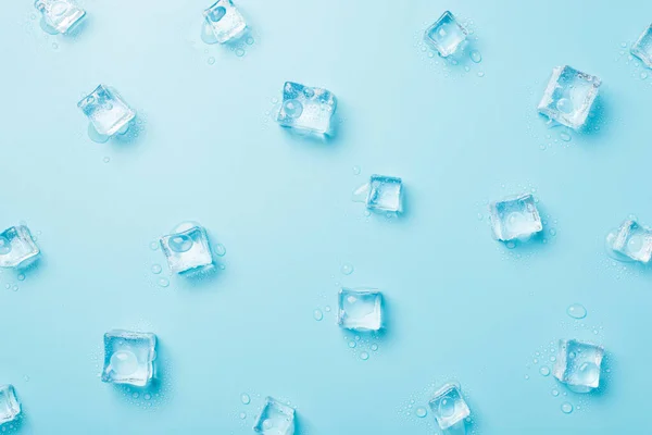 Foto Vista Superior Cubos Hielo Dispersos Derretidos Sobre Fondo Azul — Foto de Stock