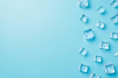 Mavi arkaplanda kopyalanmış saydam buz küplerinin üzerinde
