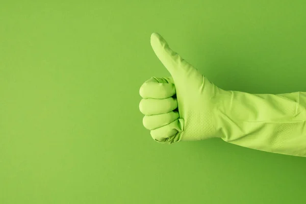 緑色の手袋の手のプロフィール写真コピースペースと隔離された緑色の背景に親指を立てる — ストック写真