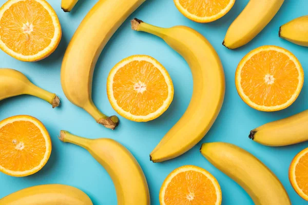 Foto Von Oben Von Verstreuten Ungeschälten Bananen Und Geschnittenen Orangen — Stockfoto