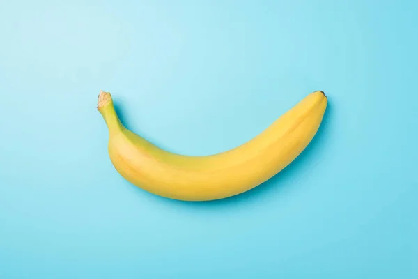 一张未剥皮的成熟香蕉在中间 孤立的淡蓝色背景 空白区域的俯瞰照片 — 图库照片