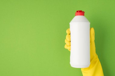 Yeşil arka planda izole edilmiş ellerde deterjan resmi var.