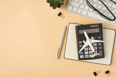 Klavye düzlem modelindeki bitki gözlüklerinin hesap makinesi gri planlayıcı kalemi ve izole edilmiş bej arkaplan üzerindeki klasörlerin fotosu.
