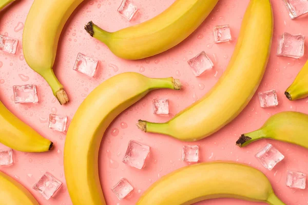 成熟的未剥皮香蕉冰块的顶部照片 在孤立的浅粉背景上滴落 — 图库照片