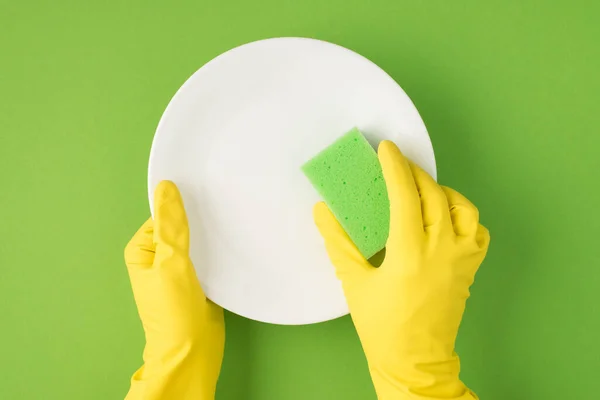 Photo Hands Yellow Gloves Plate Cellulose Sponge Washcloth Isolated Green — Stock Photo, Image