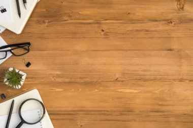 Kırtasiye defterlerinin en üst görünüm fotoğrafı. Kalem cilt kırpıcıları. Büyüteç, çiçek saksısı ve gözlük.