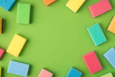 İzole edilmiş yeşil arkaplan üzerindeki çoklu renk temizleme yastıklarının ortasındaki telif boşluğunun en üstteki görüntüsü