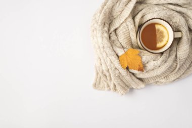 Limon sarısı sonbahar yapraklı çay fincanı ve kopyalanmış beyaz arka planda eşarp.