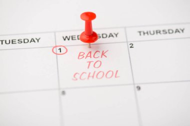 Mark 'ın takvimdeki ilk kırmızı yazıda çekilmiş yakın plan fotoğrafı kırmızı raptiyeyle okula geri dönüyor.