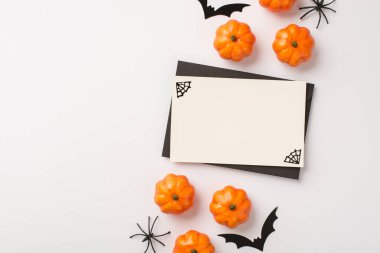 Beyaz kartın üstünde siyah çerçeve ve cadılar bayramı dekorasyonu örümcekleri beyaz arka planda izole edilmiş balkabağı ve yarasalar.