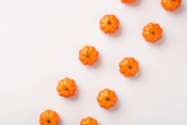 Beyaz arka planda izole edilmiş bir sürü turuncu balkabağı resmi var.