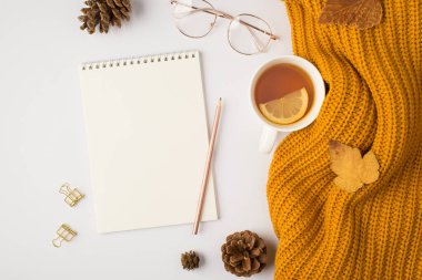 Sarı örülmüş çay fincanının üst görüntüsü. Limon sarısı sonbahar yapraklı. Altın cilt.