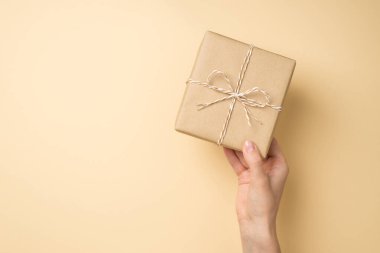 El sanatları el yapımı kağıt hediye kutusunun izole edilmiş bej arka planda sicim yayı ve boş alan ile çekilmiş ilk resmi.
