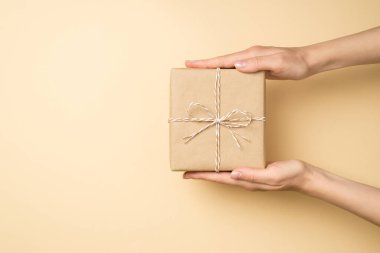 Birinci şahıs resmi, el sanatları el sanatları el kamerası hediye kutusu, sicim yayı, izole edilmiş bej arka plan, boş alan.