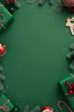 Hediye, süs eşyası, şeker kamışı, çam ağacı dalları ve yeşil bir arka planda ayarlanmış ahşap bir ren geyiği kesiminin yer aldığı hareketli dikey Noel sahnesi bayram kutlamalarını davet ediyor.