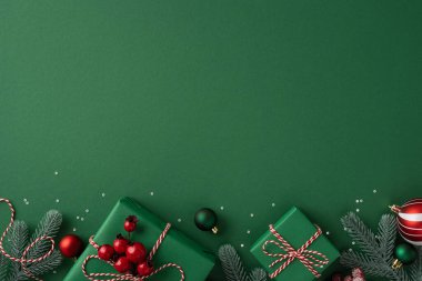 Paketli hediyeler, çam dalları, böğürtlen ve süslerin yer aldığı yeşil bayram arkaplanı Noel ve Yeni Yıl kutlamalarını anımsatıyor