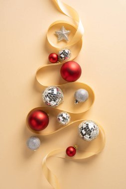 Kırmızı ve gümüş süslemelerle bir ağaç oluşturan kıvrımlı kurdeleyle Noel ağacı şeklindeki dikey Noel ağacı Noel ve yeni yıl ruhunu yakalıyor. Cazibe ve ışıltıyla neşeli bir karşılama havası