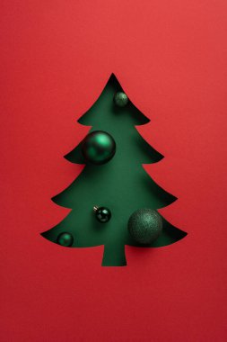 Minimalist yeşil bir Noel ağacı, parlak süslemelerle koyu kırmızı bir zemin oluşturarak neşeli bir tatil sahnesi oluşturur. Noel, yeni yıl kutlamaları ve mevsimlik hediye kampanyaları için ideal.