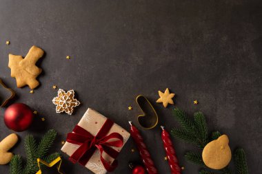 Paketlenmiş bir hediye, zencefilli kurabiye, kırmızı süs, mum, kurdele ve her zaman yeşil olan dalların yer aldığı bir tatil hayatı sıcak Noel ve yeni yıl havasını uyandırıyor.