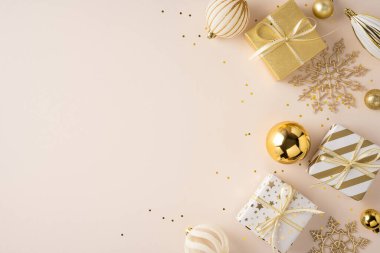 Paketli hediyeler, altın süsler ve kar taneleri dekoru ile bej renkli yumuşak arka plan Noel ve yeni yıl kutlamaları için bayram ruhunu ve şenlik havasını yakalıyor