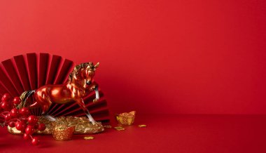 Altın bir at, bozuk para ve Çin Yeni Yılı 'nı ve refahı sembolize eden bir yelpazeli kırmızı bir sahnenin yan görüntüsü.