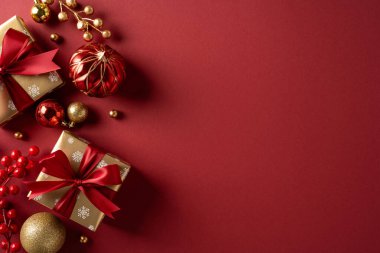 Kırmızı kurdeleye sarılı hediyeler, Noel süslerinin yanında otururlar. Kırmızı bir zemin üzerinde. Kutlama, şenlik havası ve yeni yılı sıcak bir bayram ortamında kutlarlar.