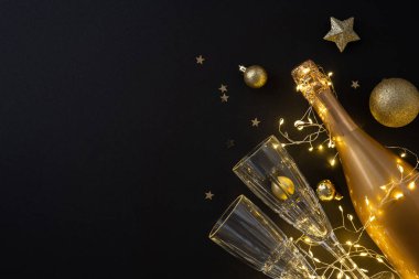 Şampanya şişesinden ve küçük ışıklı kristal bardaklardan gelen altın parıltı Noel ve yeni yıl kutlaması için şenlikli bir sahne hazırladı.