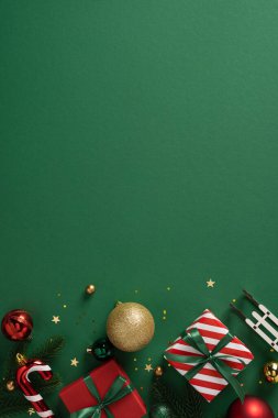 Yeşil arka planda paketlenmiş hediyeler, kurdeleler, takılar ve şenlikli dekorlar Noel ve yeni yıl kutlamaları ve mevsimsel markalaşma için ideal.