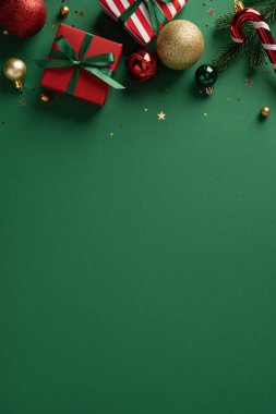 Canlı dikey Noel hediye kutuları, mücevherler ve şeker kamışı yeşil bir zemin süslüyor, şenlikli kutlamalar ve yeni yıl kutlamaları ima ediliyor.