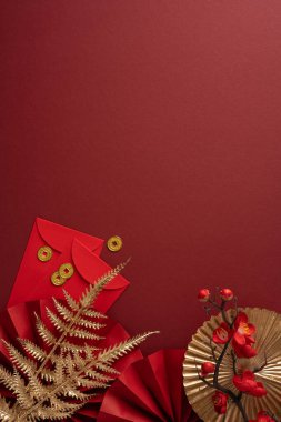 Zarflar, madeni paralar ve dekoratif unsurlarla zengin dikey kırmızı zemin Çin Yeni Yıl havasını çağrıştırıyor. İletiler için ideal