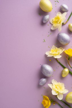 Pastel dikey yumurtalar ve nergis çiçekleri yumuşak bir menekşe zemin üzerinde uzanır, bahar çiçekleri, parlak renkler ve nazik dekoratif aksanlarla neşeli bir Paskalya sahnesi yaratır.