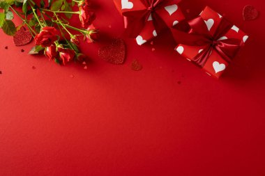 Kırmızı güllerin, kalp aksanlarının ve hediye kutularının bulunduğu bir Sevgililer Günü sahnesi. Sevgililer Günü kutlamaları için sevgi, romantizm ve sevgi iletiliyor.