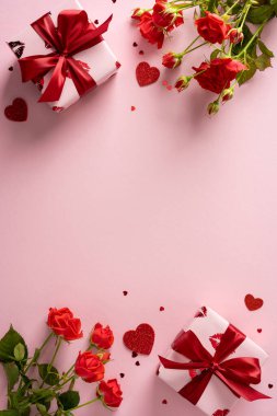 Hediye kutuları, kırmızı kurdeleler, güller ve dağılmış kalplerle pembe dikey arka plan Sevgililer Günü kutlaması, romantizm, tebrik kartları ve hediye promosyonu için ideal