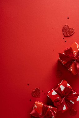 Parlak kalpli, parlak kırmızı bir zemin, düzgün paketlenmiş hediyeler, yay aksanları ve sevgililer günü kutlamaları için ideal şenlik havası, romantik kampanyalar ve hediyelerle ilgili görseller.