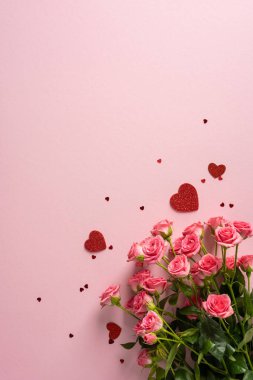 Dikey, yumuşak, pembe bir arka plan, parlak kırmızı kalplerin yüzeye saçıldığı, sıcak, romantik bir sevgililer günü havası ve dekoratif bir cazibe yaratan pembe gül saplarını destekler.