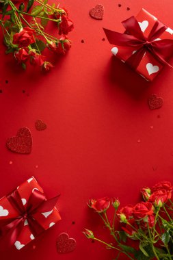 Kırmızı güller, kalp süslemeleri ve beyaz kalpli hediye kutuları içeren canlı dikey sevgililer günü sahnesi. Romantizm, hediyeler, tebrik kartları ve Sevgililer Günü görselleri için mükemmel.
