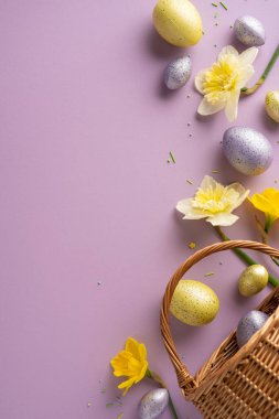 Pastel dikey Paskalya yumurtaları ve parlak nergisler sepetten lavanta arka planına dökülüp Paskalya dekoru, tebrik kartları ve mevsimlik projeler için ideal neşeli bir bahar sahnesi yaratıyorlar.