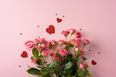 Canlı pembe güller romantik bir sevgililer günü sahnesi yaratır yumuşak pembe arka planda parlak kalpler, tebrik kartları ve aşk temalı kampanyalar için ideal.