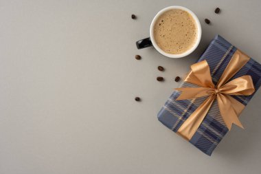Sıcak bir kahve fincanı, ekose bir hediye kutusunun yanında, altın bir kurdeleyle bağlanmış, Babalar Günü hediyeleri ve kutlamalar için mükemmel, sıcaklığı, özeni ve hediyeleri ileten,